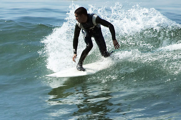 surfer riding the waves while wearing a wetsuit